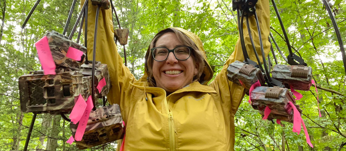 Woman holding cameras in forest