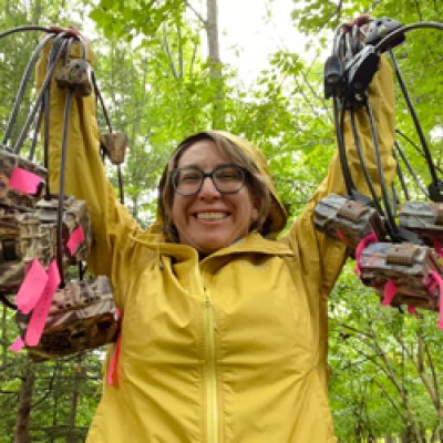 Woman holding cameras in forest